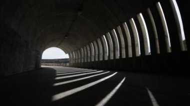 Elini yürüyüş ve bir brutalist beton tüneli getting kamera tuttum. Işıklar ve gölgeler windows, açıklıklar, tünel içinde tarafından yapılan rithms. Sokak infraestructure. Arjantin, Mendoza