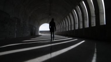 Sokak brutalist beton tünel gidiyor yürüyen kamera kadın elini tuttum. Işıklar ve gölgeler windows, açıklıklar, tünel içinde tarafından yapılan rithms. Güneş patlamaları. Arjantin, Mendoza