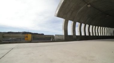Elini doğru yürüyüş ve brutalist beton tünelde getting kamera tuttum. Işıklar ve gölgeler windows, açıklıklar, tünel içinde tarafından yapılan rithms. Sokak infraestructure. Arjantin, Mendoza