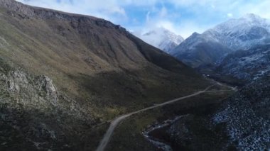 Tunuyan Vadisi hava dron sahne. Karlı tepe yan ve arka plan, Andes Dağları. Bulutlar ve mavi gökyüzü, mistic manzara. Geriye doğru hareket kamera. Mendoza, Arjantin