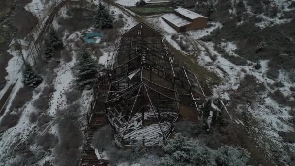空中ドローンのシーンは 灰色の雪の日に燃やされたホテルの建物は 古いを破壊しました 金属の構造および失われたホテル周辺の構造の一般的なビュー バジェ アルゼンチン — ストック動画