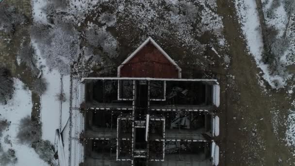 空中无人机现场被毁的建筑 老烧酒店在雪天 建筑的金属结构概况和房间分布的顶部视图 相机沿着丢失的酒店移动 — 图库视频影像