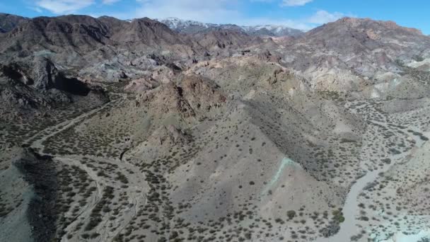 Escena aérea de drones de montañas arenosas erosionadas. Fondo nevado. Paisaje desértico. Uspalllata, Mendoza, Argentina — Vídeo de stock