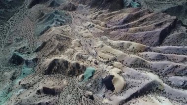 Hava senital dron sahne renkli kumlu ve kayalık Dağları. Mavi, yeşil, sarı, beyaz, mor kum tepeleri ile bitki örtüsü, erozyona uğramış peyzaj Uspallata, Mendoza, Argentina.