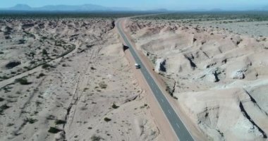 Van gibi arasında jeolojik oluşumlar, erozyona uğramış sandrock dağlar, kamyonet ve karavan römork ev ile hava dron sahne gullies Milli Parkı Talampaya, dünya doğal mirası, La Rioja, Arjantin.