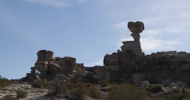 White eroded rocky landscape with cliffs, dry rivers and tall rock formations. Submarine formation, Moon Valley. Argentinian flag in scene. Ischigualasto Provincial Park, Rioja province — Stock Video