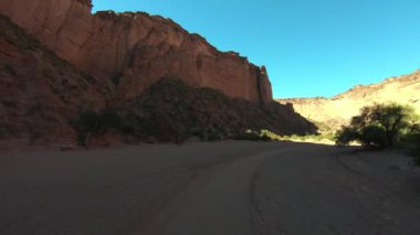 Talampaya Kırmızı Kanyon Milli Parkı içinde seyahat. Kırmızı uzun boylu kayalık duvar kenarlarında, doğal bitki örtüsü. Rioja Eyaleti, Arjantin. Dünya doğal mirası.