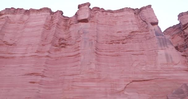 Detail of tall red rock walls of Talampaya Canyon in National Park. Camera panning from top to the floor. Geomorphical formation. World Natural Heritage — Stock Video