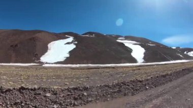 Kayalık karlı tepeleri ve sarı otları ile Kuru vadi üzerinden seyahat. Hızlı sahne. Brava Lagoon, Andes için macera gezi. Rioja Eyaleti, Arjantin