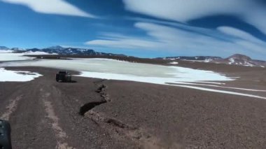 4 x 4 Van yüksek dağ altiplane, donmuş lagün için yoldan ulaşan. Siyah ve beyaz dağlar ve arka plan, valcanoes. Excursiont Brava lagün için. Rioja il
