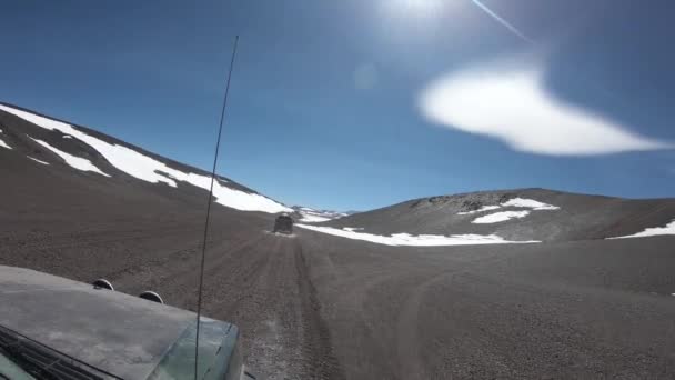 フロントに道路オフ他の車になります 雪山と背景の火山の黒い 風成層 ロッキーの風景です ブラバ ラグーン リオハ州 — ストック動画