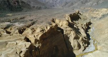 Famatina dağlar ve sarı nehir Ocre kanyonda hava dron sahne. Kamera kayalıklarla, su, gullies, katmanlar, altın, kumtaşı erozyona uğramış manzara geriye doğru artan taşır. La rioja.