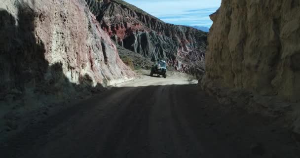 由被侵蚀的砂岩 法马蒂娜山脉组成的五颜六色的山空中无人机场景 四轮驱动面包车 有婴儿的妇女坐在车盖上 相机在汽车上方快速经过 Pesebre — 图库视频影像