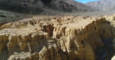 Famatina dağlar, sarı nehir kanyonda Ocre hava dron sahne. Kamera cliff doğru taşır. Panoramik nehir ve bütün manzara. La Rioja, Arjantin.