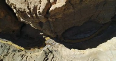 Hava senital dron Ocre Kanyon Famatina dağlar ve sarı nehir sahne. Kamera geçen Cliff'in sınırı biter nehir yakın yakın iner. Erozyona uğramış manzara. La rioja, Arjantin.