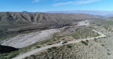 Van ile römork, kamyonet ve karavan, hava uçak sahne Famatina dağlar, tepeler yüksek kenarında çakıl yol seyahat. Sahne 4 x 4 araba ve izleme, lateral macera, riskli yolu yaklaşıyor.