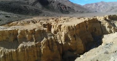 Famatina dağlar, sarı nehir kanyonda Ocre hava dron sahne. Kamera cliff doğru taşır. Panoramik nehir ve bütün manzara. La Rioja, Arjantin.