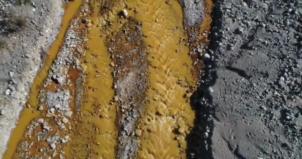 Сцена воздушного сенитального беспилотника с водой, текущей из Желтой реки в горах Фаматина, Ла-Риоха, Аргентина. Золотая вода. Камера движется вдоль реки . — стоковое видео