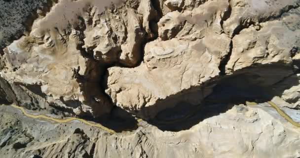 Aerial senital drone scene of Ocre Canyon in Famatina Mountains and Yellow river. Camera descends showing golden river, cliffs, general eroded landscape. La rioja, Argentina. — Stock Video