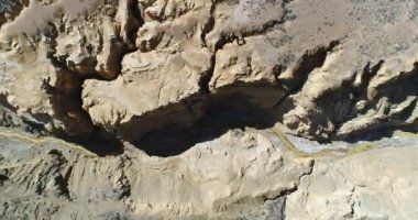 Hava senital dron Ocre Kanyon Famatina dağlar ve sarı nehir sahne. Kamera yükselir. Kanyon gullies, Altın Nehri, cliff ve erozyona uğramış peyzaj ile genel bakış. La rioja, Arjantin