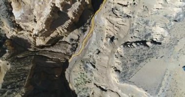 Hava senital dron Ocre Kanyon Famatina dağlar ve sarı nehir sahne. Kamera nehir boyunca taşır. Ayrıntı gullies, Altın Nehri, cliff ve erozyona uğramış manzara. La rioja