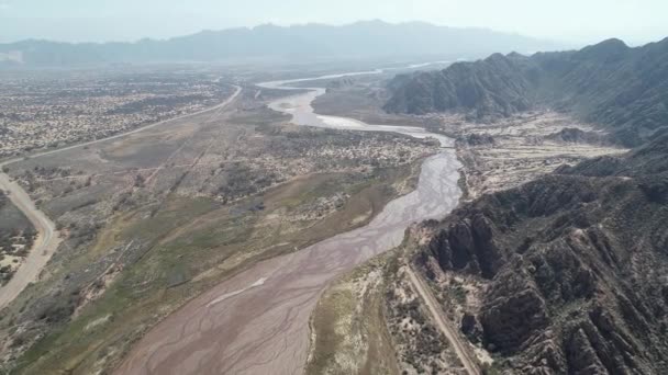 Cena de drones aéreos de Fiambala sinuando rio e montanhas rochosas secas em alta altitude. Paisagem de vale deserta amd monte vegetação. Antecedentes dos Andes. Catamarca, Argentina — Vídeo de Stock