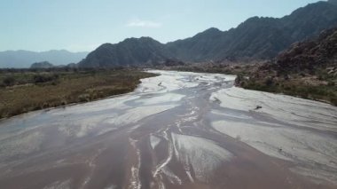 Hava dron kum Fiambala kıvrımlı sahne Nehri ve kum tepeleri ile ormanda, kamera su üzerinde seyahat. Rocky Dağları vasıl geçmiş kuru. Cuyo, Catamarca, Argentina.