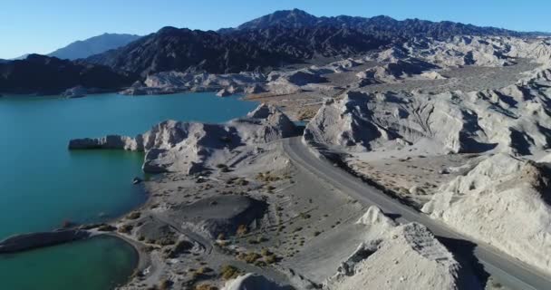 湖と浸食された山々 の空中ドローン シーン 海岸や道路に飛んでいます 水の上の太陽の反射 クエスタ ビエント フアン州 — ストック動画