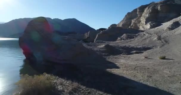 白色砂岩岩石和蓝色泻湖的空中无人机场景 在地质构造和水面附近飞行 阳光的背光 Cuesta Del 佳大坝 牛仔竞技表演 圣胡安 阿根廷 — 图库视频影像