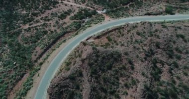 Hava senital yol araba kapısı kırmızı kumtaşı kayalıklarla seyahat ile sahne robot. Geçit ve kanyonlar üst yerel bitki örtüsü ile tarafında. Rioja il. Famtina Dağları