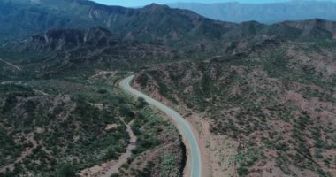 Kırmızı kumtaşı kayalıklarla hava dron sahne. Üstünde belgili tanımlık tepe uçan geçit ve kanyonlar yerel bitki örtüsü ile yukarıda. Araba kapısı manzara olan yol. Rioja il. Famtina Dağları