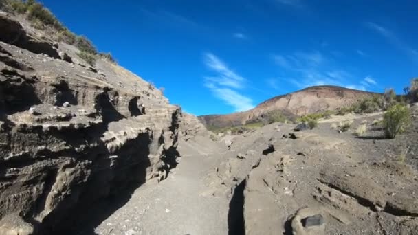 Caminhando pelo rio rochoso seco em direção ao vulcão Malacara. Turismo de aventura em ambiente natural. Mendoza, Argentina . — Vídeo de Stock