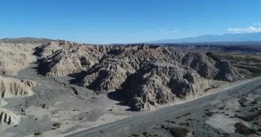 Hava dron sahne erozyona uğramış dağlar. Kuru nehrine doğru tepeler arasında seyahat. Garip organik kule formları. Manzara kuru. San Juan Eyaleti, Arjantin