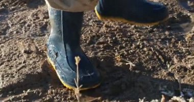 Ayrıntı çocuğun yağmur çamur ağaç brunch ile kirli su hareketli bir Gölü sahilinde oynayan botlar. Cuesta del viento Barajı, San Juan Eyaleti, Arjantin