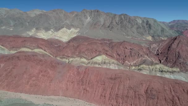 空中无人机现场五颜六色的山 阿根廷卡塔马卡省干涸河流和沟渠的砂岩景观 接近和经过丘陵 — 图库视频影像