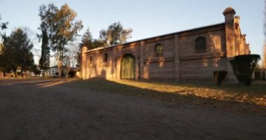 Gün batımı yaklaşan kiler tuğla İnşaat ahşap kapısı, kırsal girme. Yeşil kapı detay için hızlı sahne genel görünümden. İçecek endüstrisi. Mendoza, Arjantin