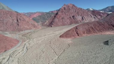 Kırmızı beyaz kumlu Vadisi, yol geçiş manzara dağlarda hava dron sahne. Uçan erozyona uğramış renkli yatay doğru. Kuru dere. Catamarca Eyaleti, Arjantin.