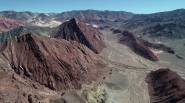 Renkli erozyona uğramış dağlar hava dron sahne. Kırmızı kumtaşı katmanı yatay kuru nehir ve gullies, catamarca Eyaleti, Arjantin. Vadi hareketli kamera
