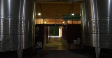 Şarap üretimi sanayi. Stabilize kamera tuğla tanklar tarafından geçen şarap metal tank dan hall yol boyunca seyahat elini tuttum. Mendoza, Arjantin. 