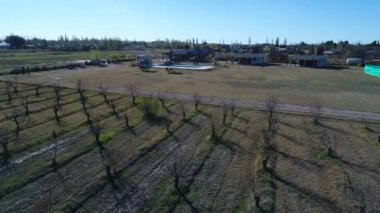 Hava dron sahne, şehir banliyölerinde özel kentleşme. Havuzu, saman şemsiye ve plaj sandalyeleri ile eğlence parkı. Aynı evler ve diğer urbanizations, arka plan. Kamera havuza doğru hareket eder.