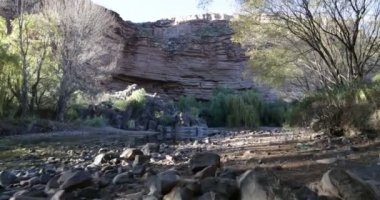 Rocky Atuel riverbend üzerinde günbatımında yürüme. Altın saat. Mendoza, Arjantin. Uzun boylu kızıl uçurum, doğal bitki örtüsü ve arka plan, kayalık peyzaj.