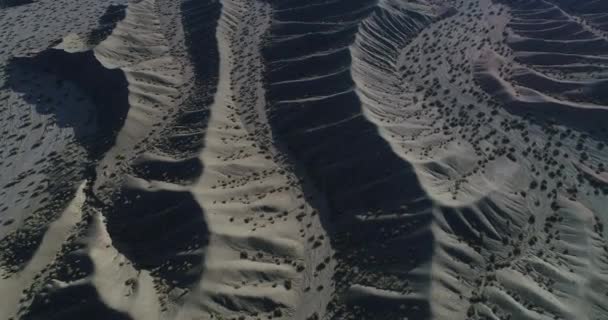 Cena do drone senital aéreo no por do sol das colinas erodidas e dos rios secos do ambiente desertic. Detalhe da terra colorida e desenho da erosão da água na paisagem. San Juan, Calingasta — Vídeo de Stock