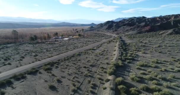 Letecká drone scéně Truck cestování přes silnici v údolí řeky mezi erodované písečných dunách. Čas západu slunce. Calingasta, San Juan, Argentina. — Stock video