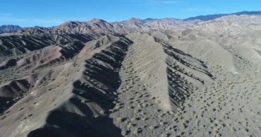 Hava dron sahne desertic Derma tepeler ve dağlar kum ve kaya yaptı. Çok yüksek descneding Kuru dere doğru uçan kamera. San Juan, Calingasta, Arjantin