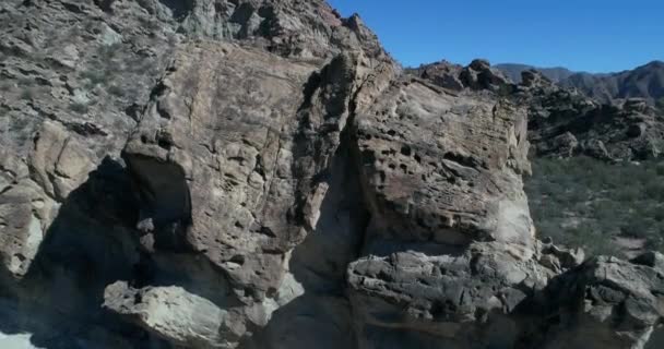 Cena de drones aéreos de vale seco e montanhas dobradas. Câmera mostra detalhes de formações rochosas que emergem da terra com ângulo, movendo-se da vista frontal para o senital. província de San Juan, Huaco, Argentina — Vídeo de Stock