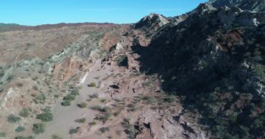 Açısı ile Dünya'dan ortaya renkli kaya oluşumları uçan hava dron sahne. Kırmızı ve beyaz kayalar katlanmış Dağları'nın en iyi görünümü. San Juan Eyaleti, Huaco, Arjantin