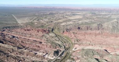 Yeşil Huaco Nehri Vadisi renkli katlanmış dağlar arasında hava dron sahne. Kırsal kasaba ve verimli toprakları arka plan. Huaco, San Juan Eyaleti, Arjantin
