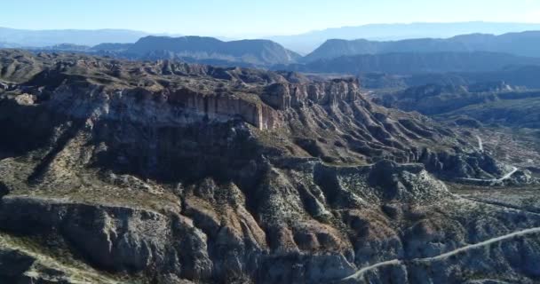 Scena aerea drone di montagne rocciose irregolari, calanchi, scogliere, alte pareti rocciose formano le colline. Paesaggio naturale. Huaco, provincia di San Juan, Argentina. Panoramica delle formazioni geologiche — Video Stock