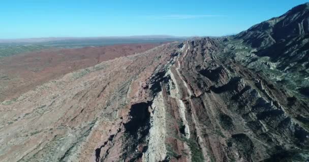 Letecká drone scéně červené a bílé krajiny složené pohoří. Fotoaparát sestupně celkový pohled na přirozené barevné vrstvy, které se ztratil v obzoru. Huaco, provincii San Juan, Argentina — Stock video