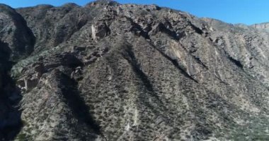 Hava dron sahne kuru katlanmış dağ yaklaşıyor. Çok yakın kayalar üstünde tepe üzerinde uçan. Vadi Huaco, San Juan Eyaleti, Arjantin itibariyle yerel bitki örtüsü ile